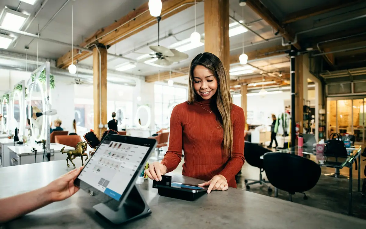 Store owner processing a customer order on a tablet point-of-sale checkout